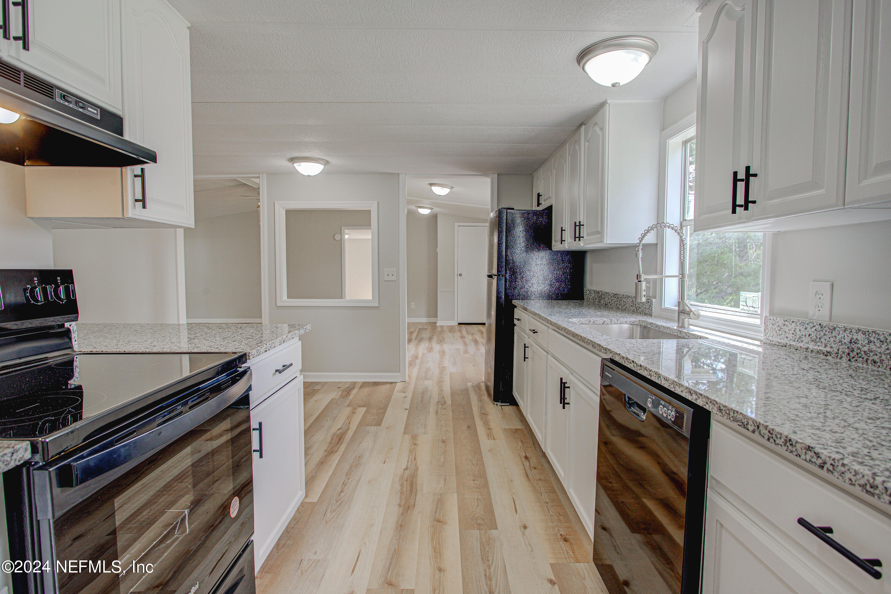 7677 Oak Forest Road Keystone Heights, FL 32656 - Photo 21 of 54 a large kitchen with granite countertop a lot of counter space and wooden floor