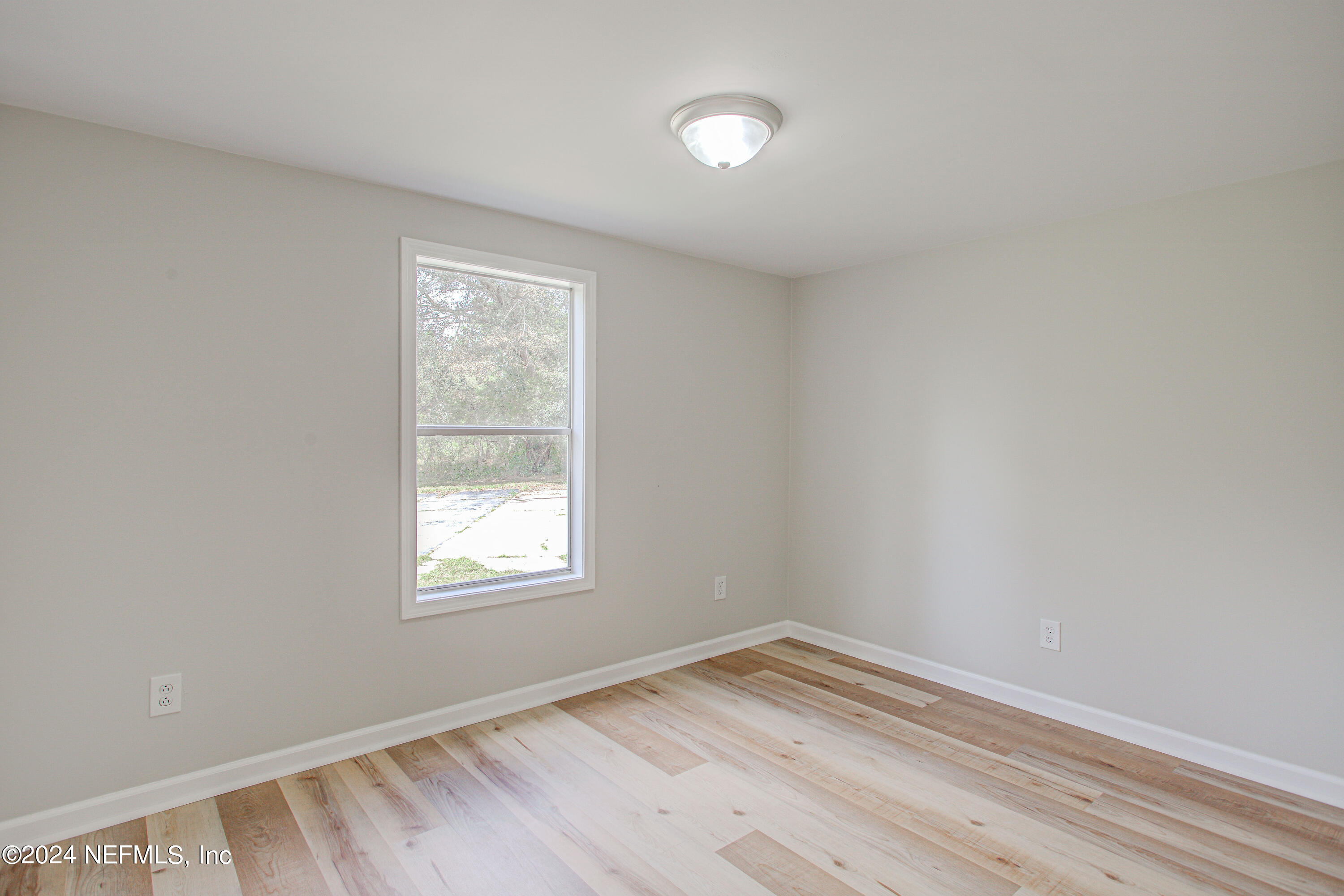 7677 Oak Forest Road Keystone Heights, FL 32656 - Photo 23 of 54 an empty room with wooden floor and windows
