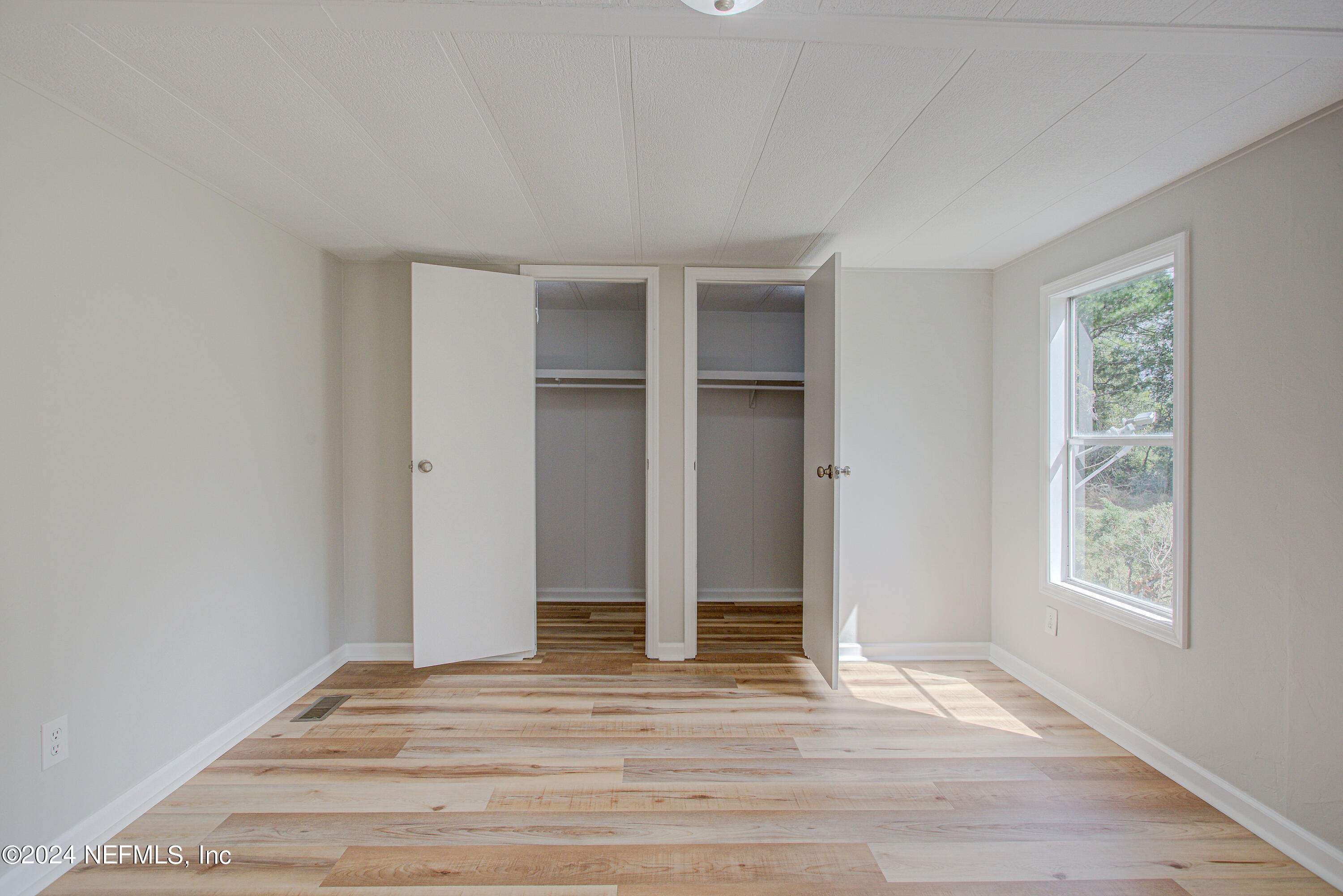 7677 Oak Forest Road Keystone Heights, FL 32656 - Photo 27 of 54 an empty room with wooden floor and windows