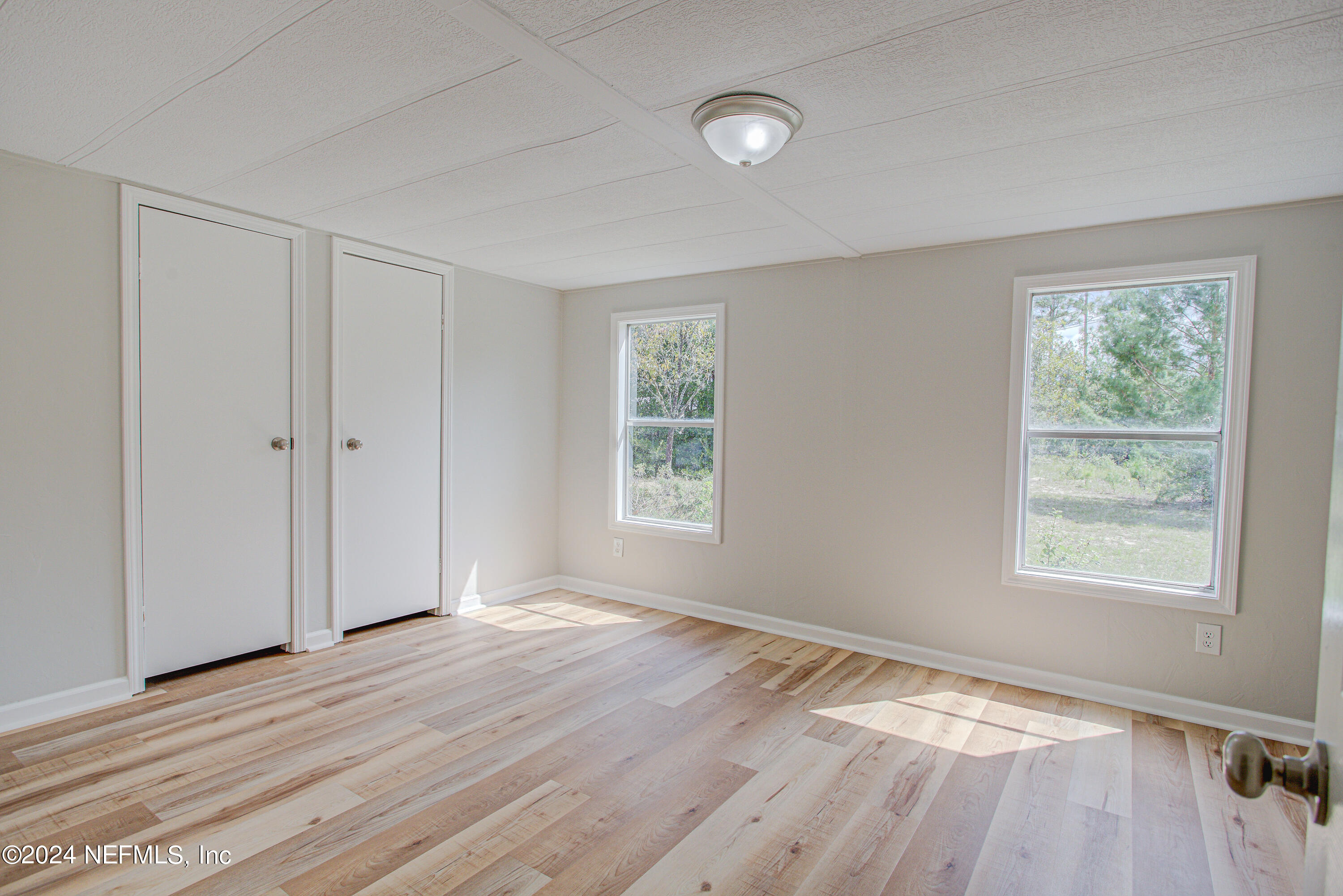 7677 Oak Forest Road Keystone Heights, FL 32656 - Photo 28 of 54 a view of an empty room with wooden floor and a window
