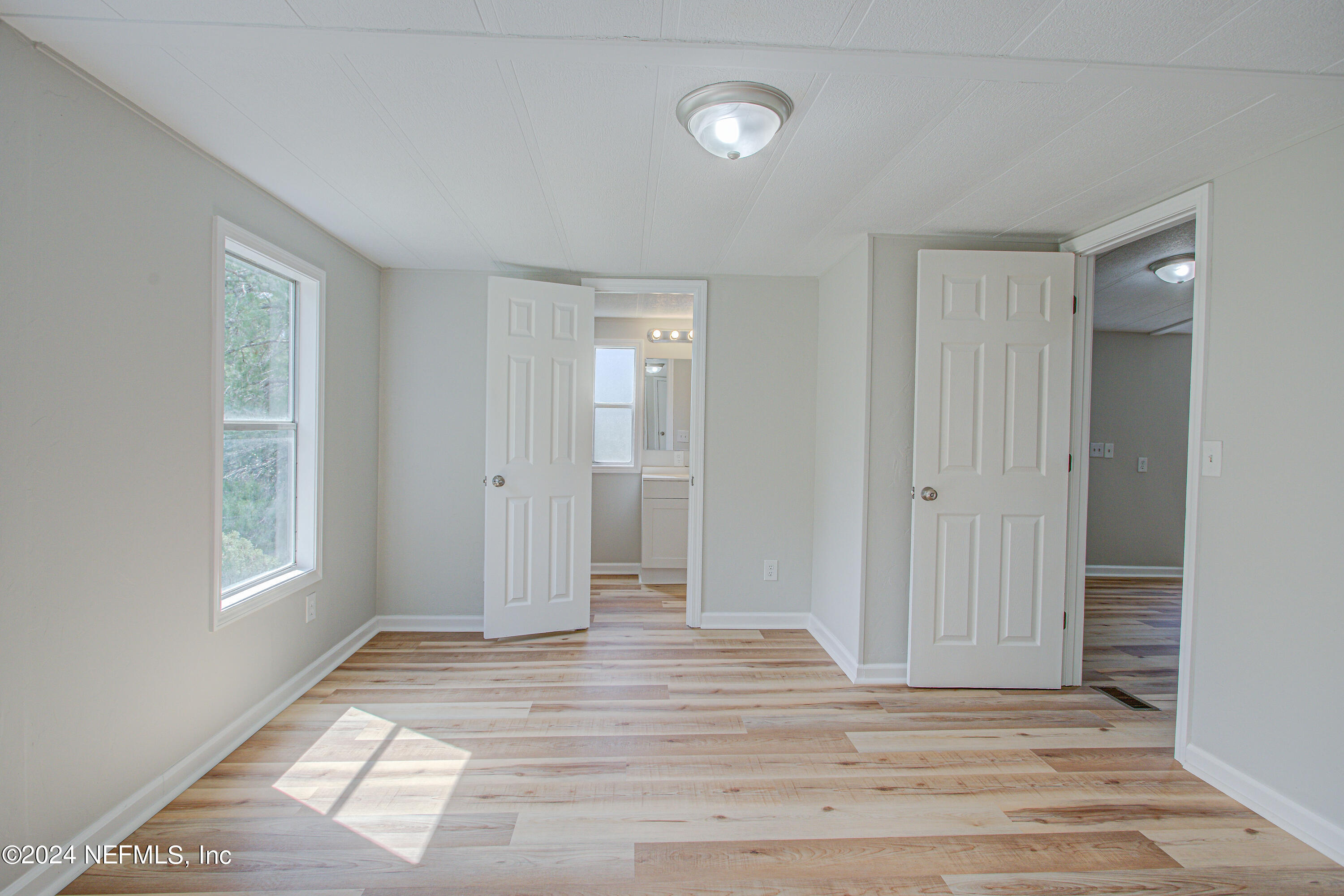 7677 Oak Forest Road Keystone Heights, FL 32656 - Photo 30 of 54 a view of empty room with window and wooden floor