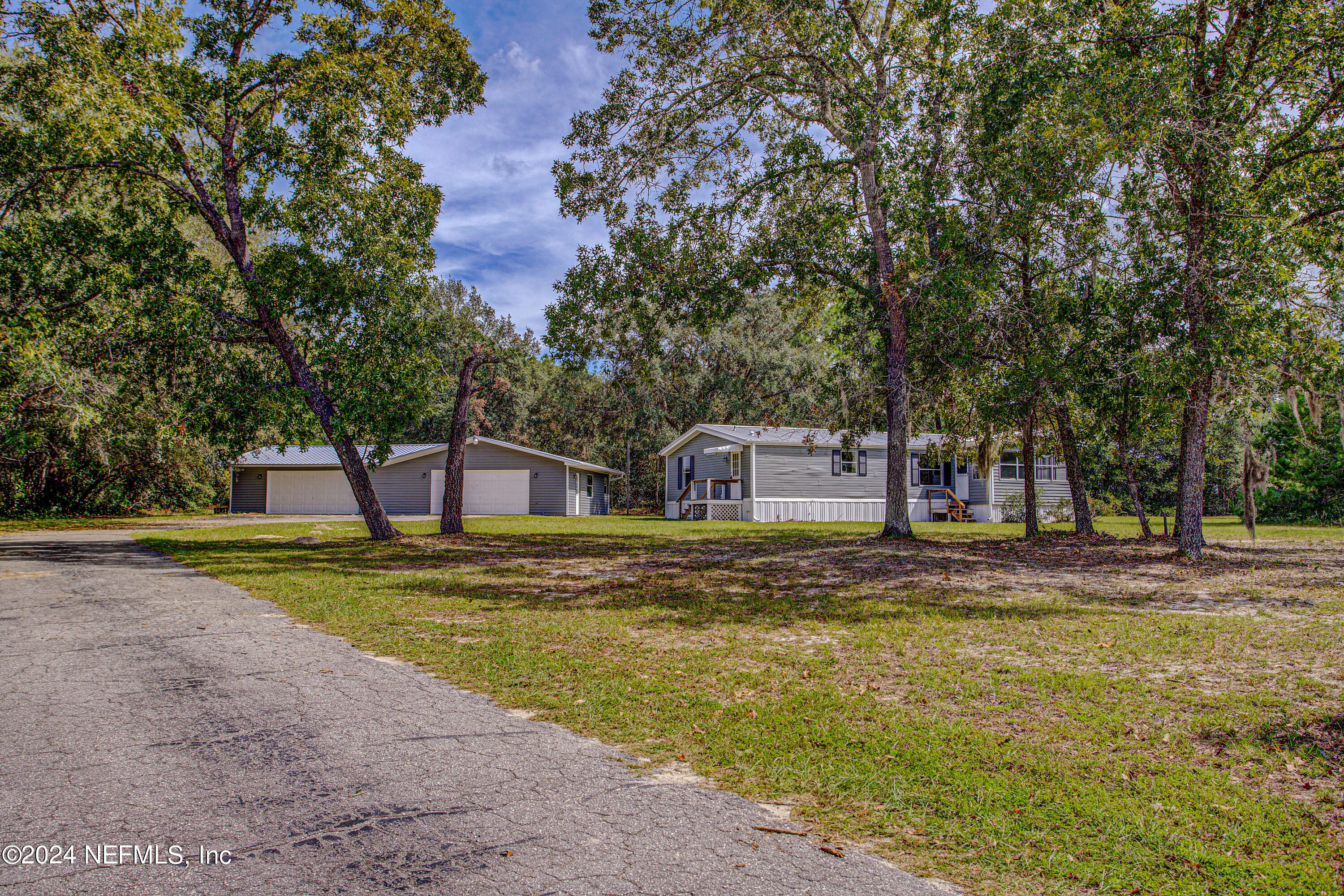 7677 Oak Forest Road Keystone Heights, FL 32656 - Photo 3 of 54 a front view of a house with a yard and trees