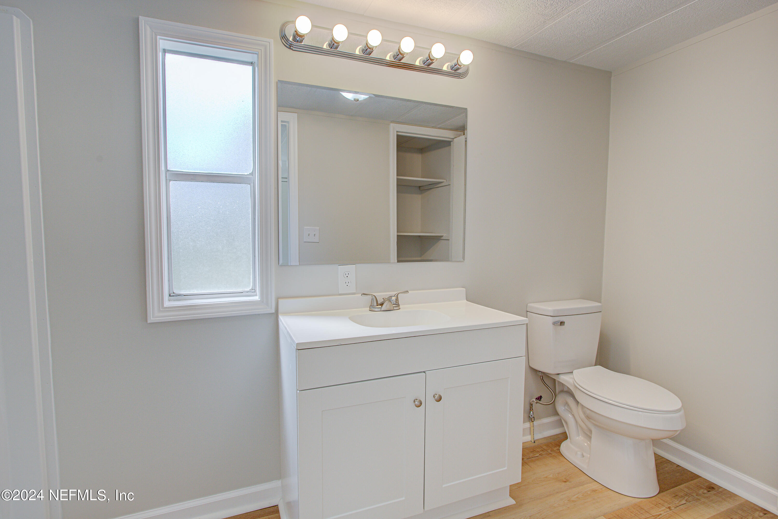 7677 Oak Forest Road Keystone Heights, FL 32656 - Photo 32 of 54 a bathroom with a toilet sink and mirror