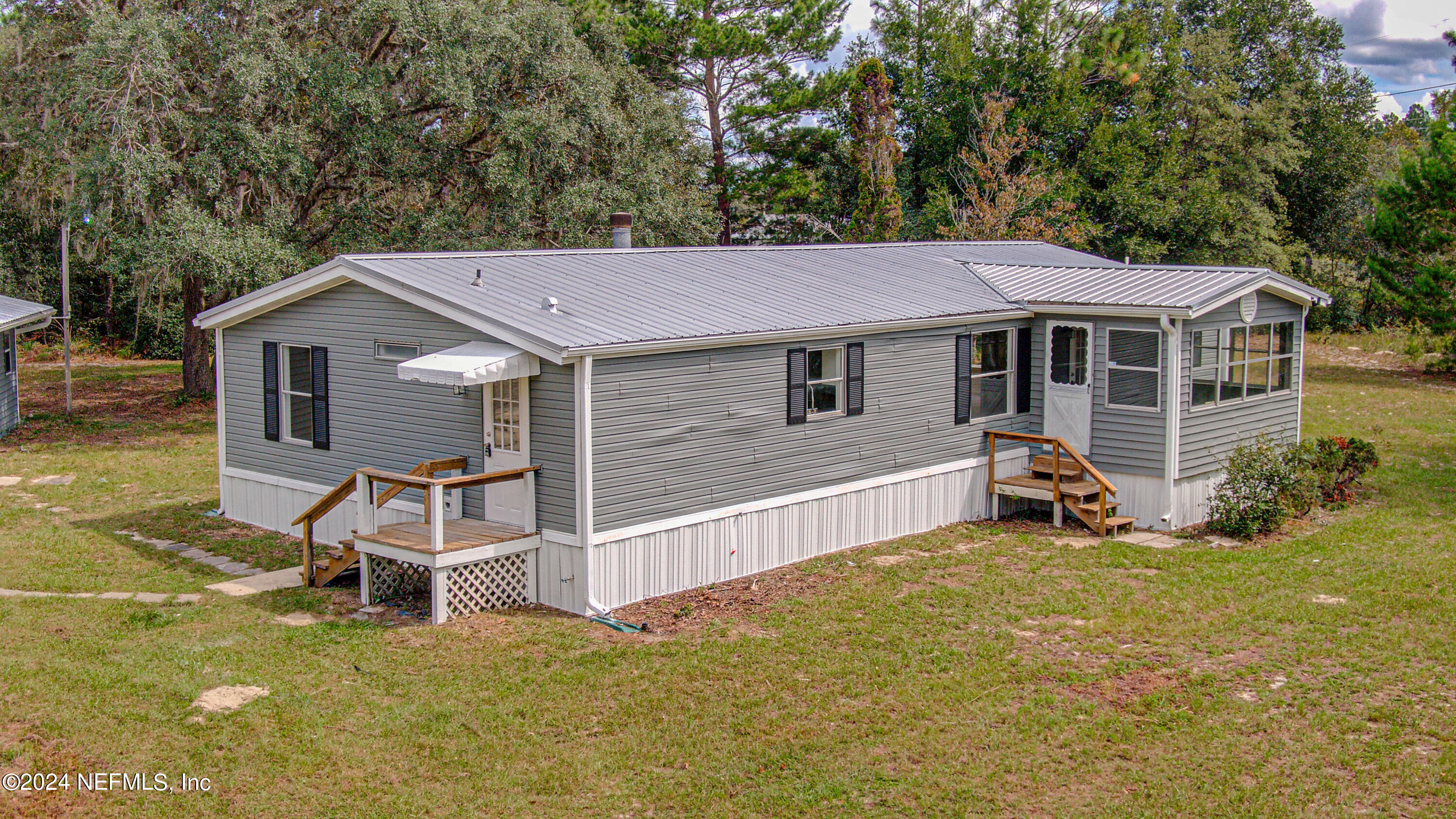 7677 Oak Forest Road Keystone Heights, FL 32656 - Photo 6 of 54 a view of a house with a yard and lawn chairs