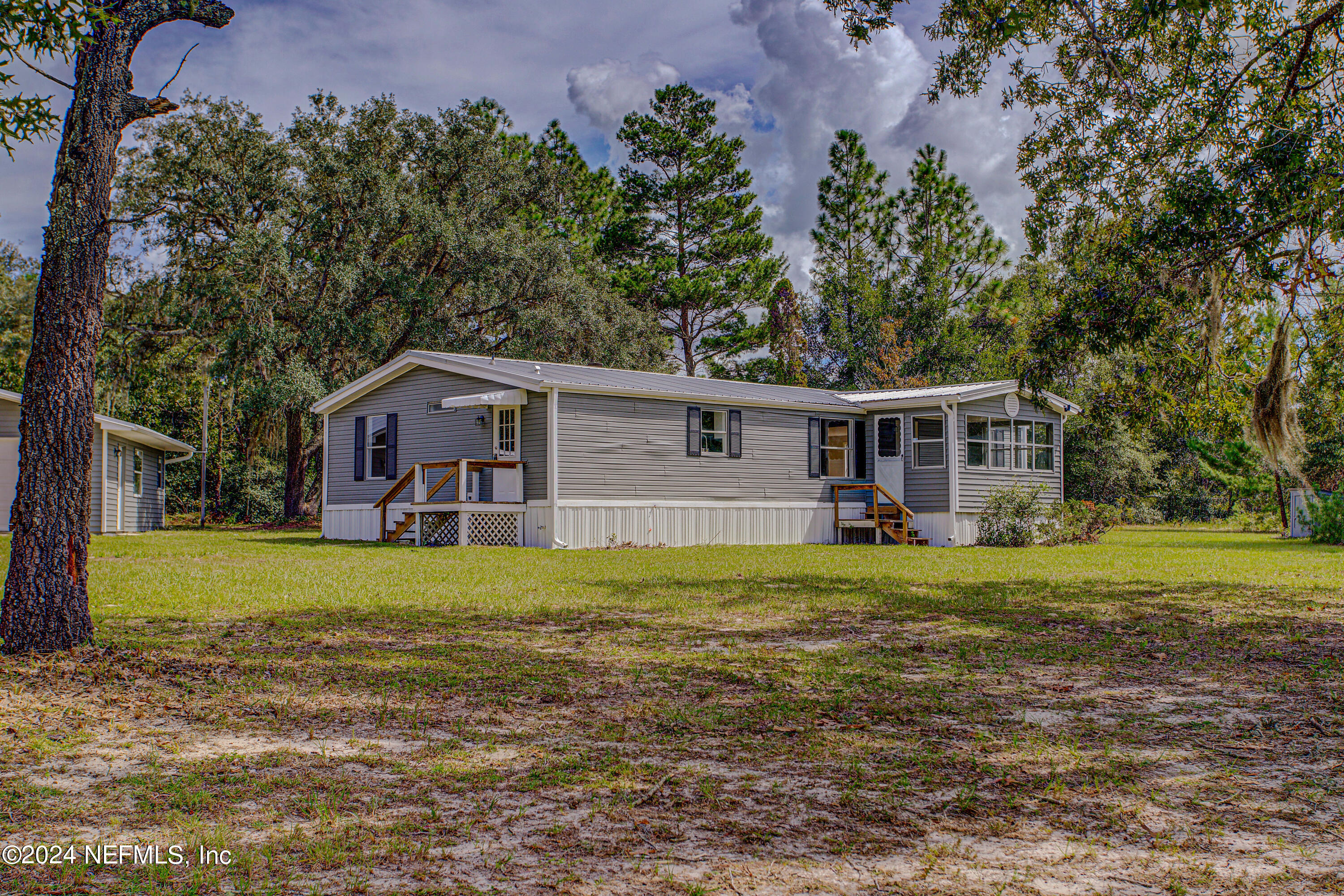 7677 Oak Forest Road Keystone Heights, FL 32656 - Photo 7 of 54 a front view of a house with a yard and trees