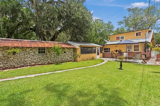 a view of an house with backyard and a tree