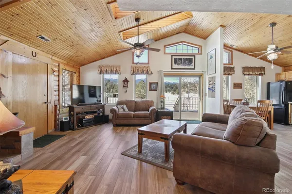 a living room with furniture ceiling fan and a rug
