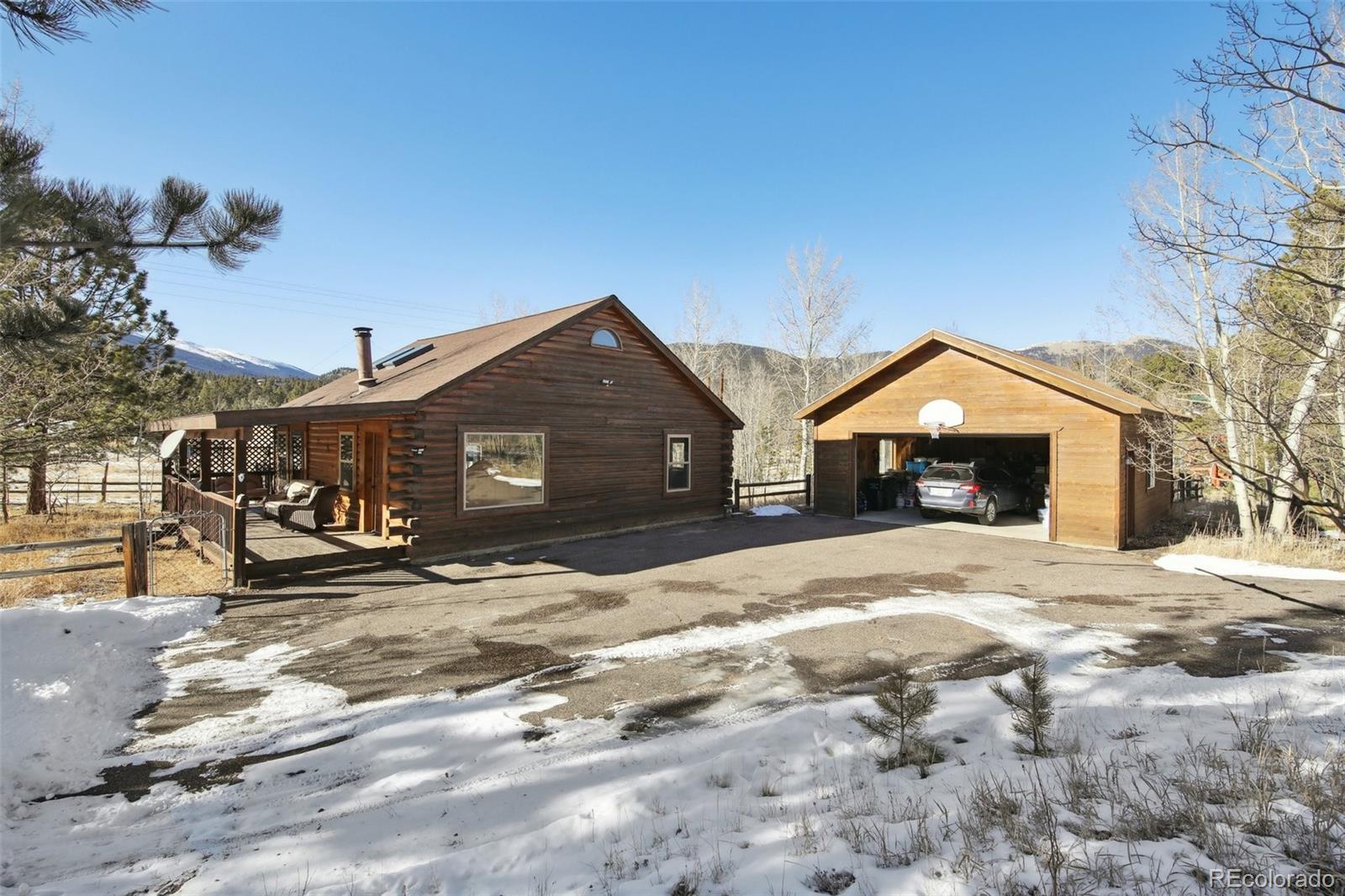 499 Clark Road Bailey, CO 80421 - Photo 3 of 27 a front view of a house with a yard covered in snow