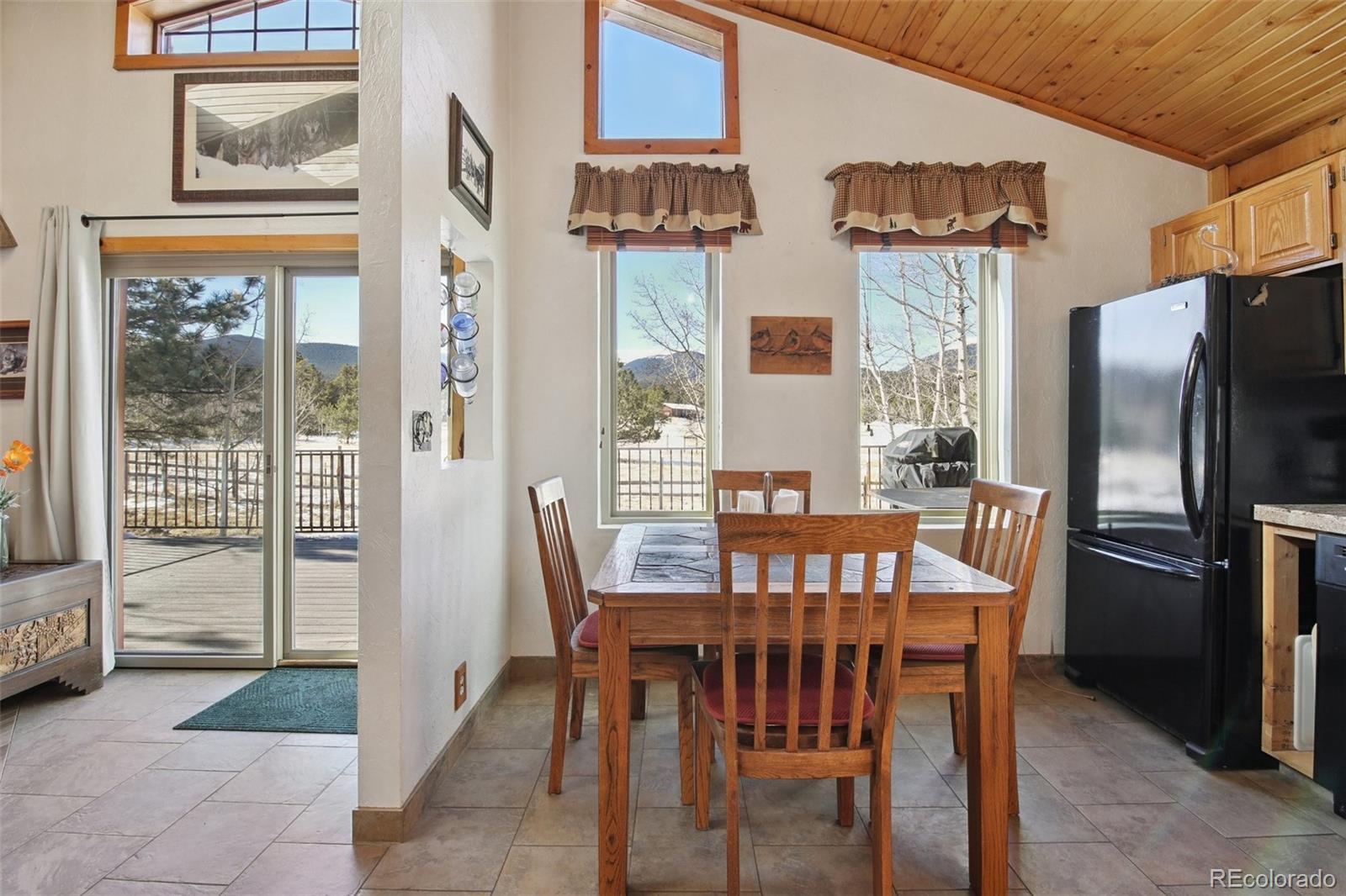 499 Clark Road Bailey, CO 80421 - Photo 8 of 27 a view of a dining room with furniture large window and refrigerator