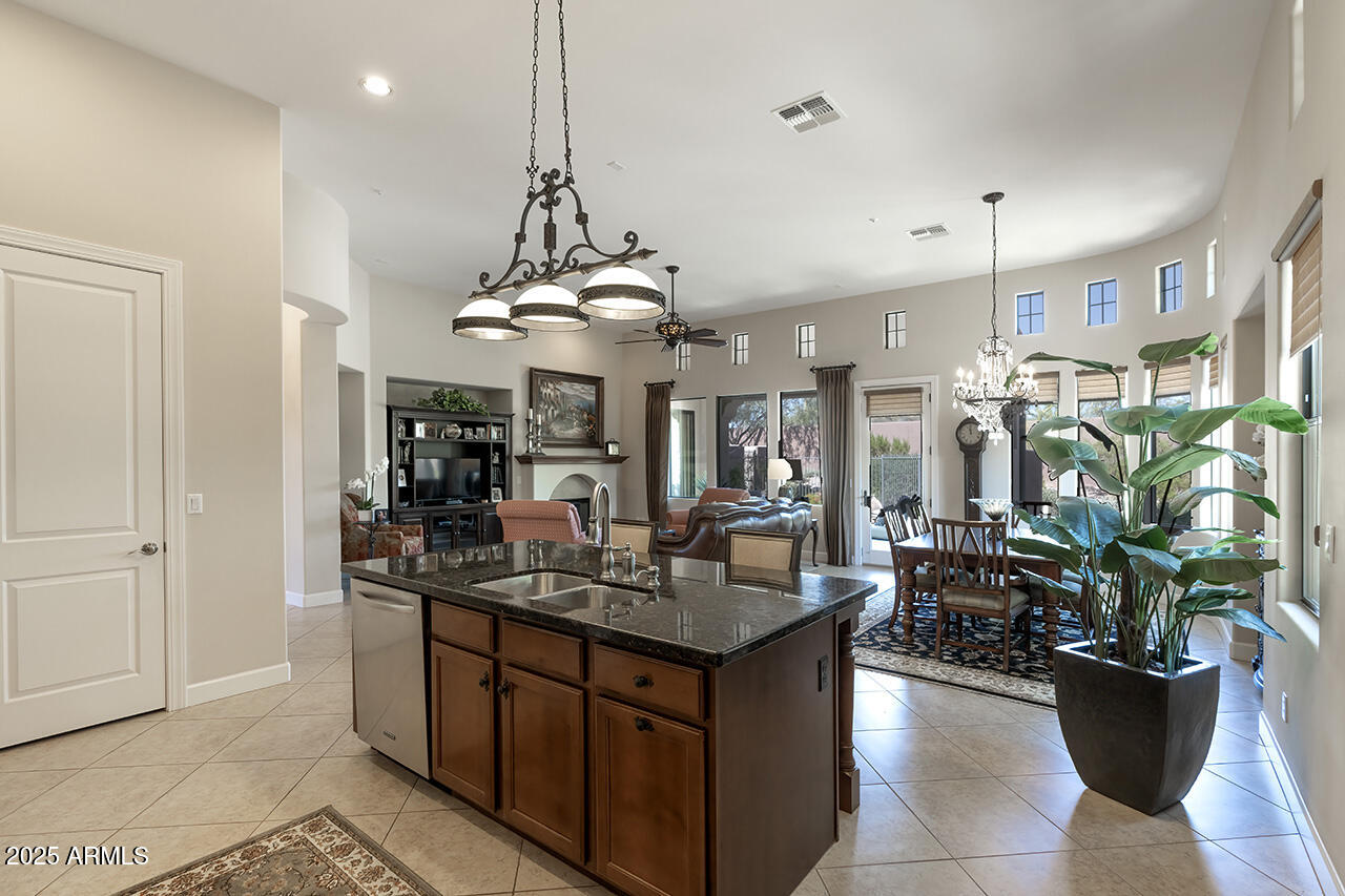 9190 East Hoverland Road Scottsdale, AZ 85255 - Photo 13 of 35 a kitchen with a sink a counter and chairs in a room
