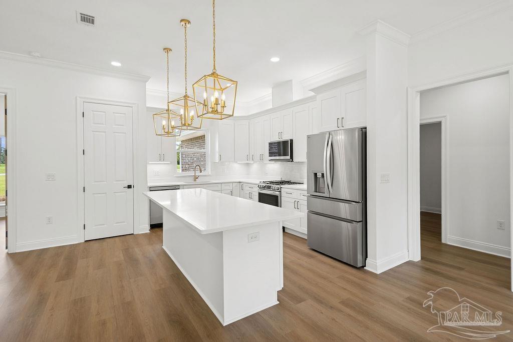 638 Ard Field Road Jay, FL 32565 - Photo 4 of 39 a kitchen with stainless steel appliances a refrigerator a sink dishwasher a kitchen island with wooden floor and cabinets