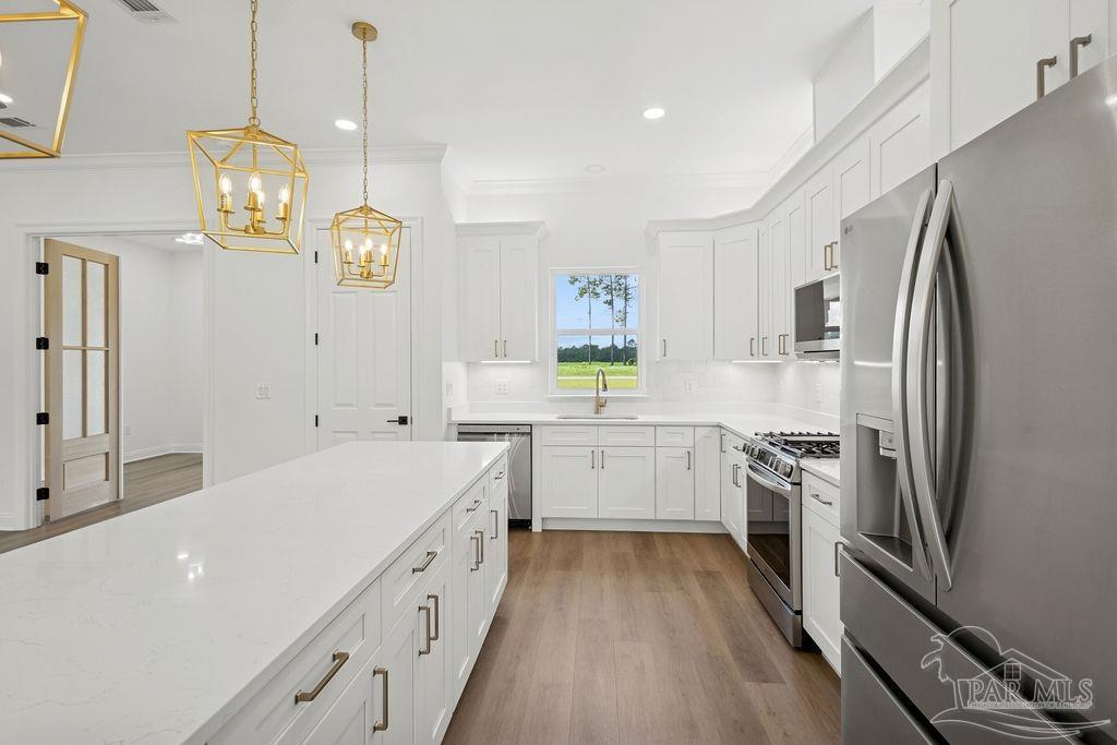 638 Ard Field Road Jay, FL 32565 - Photo 5 of 39 a large white kitchen with a refrigerator a stove a sink dishwasher a oven with a dining table and chairs