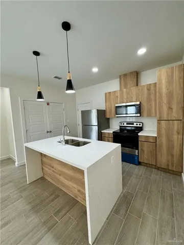 a kitchen with kitchen island a sink a stove a refrigerator and white cabinets