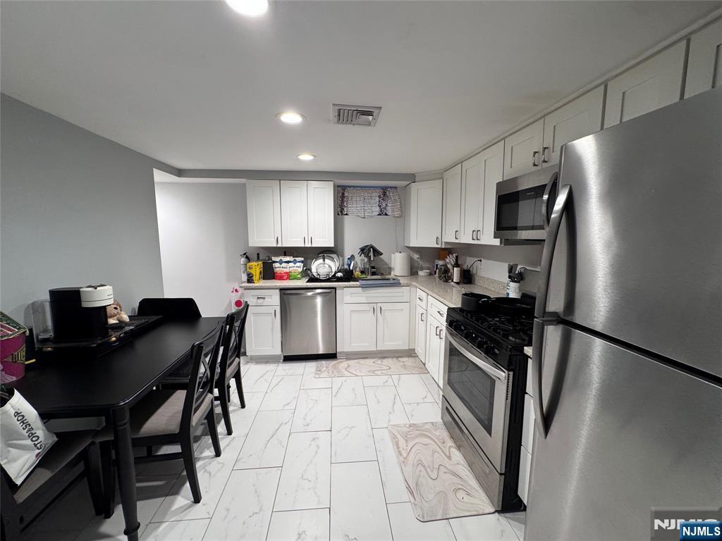126 Riverside Avenue, Unit 1 Lyndhurst, NJ 07071 - Photo 5 of 10 a kitchen with a table chairs refrigerator and a sink