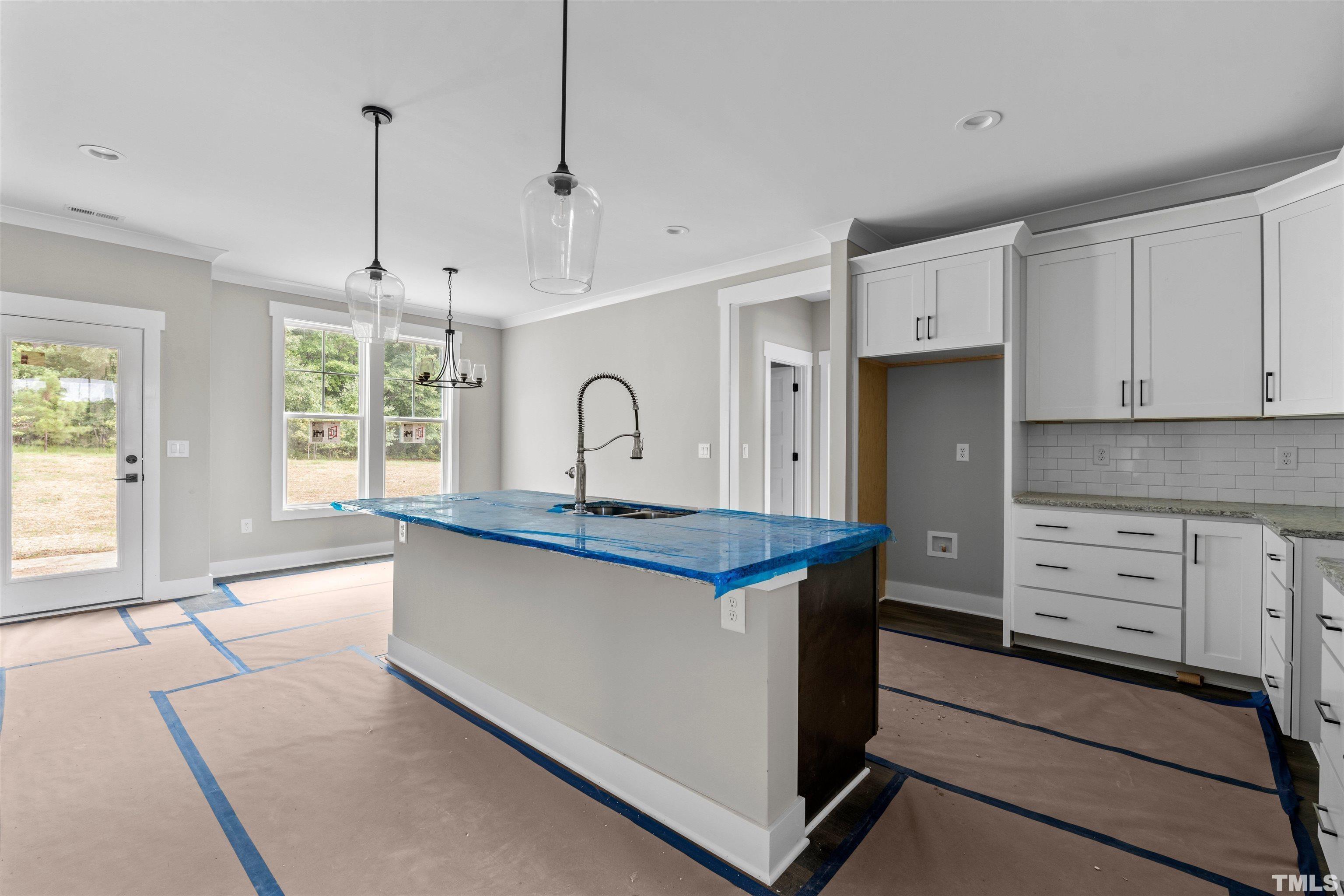 97 Buckstone Place Willow Spring, NC 27592 - Photo 13 of 21 a kitchen with stainless steel appliances granite countertop a stove a sink a refrigerator and white cabinets with wooden floor