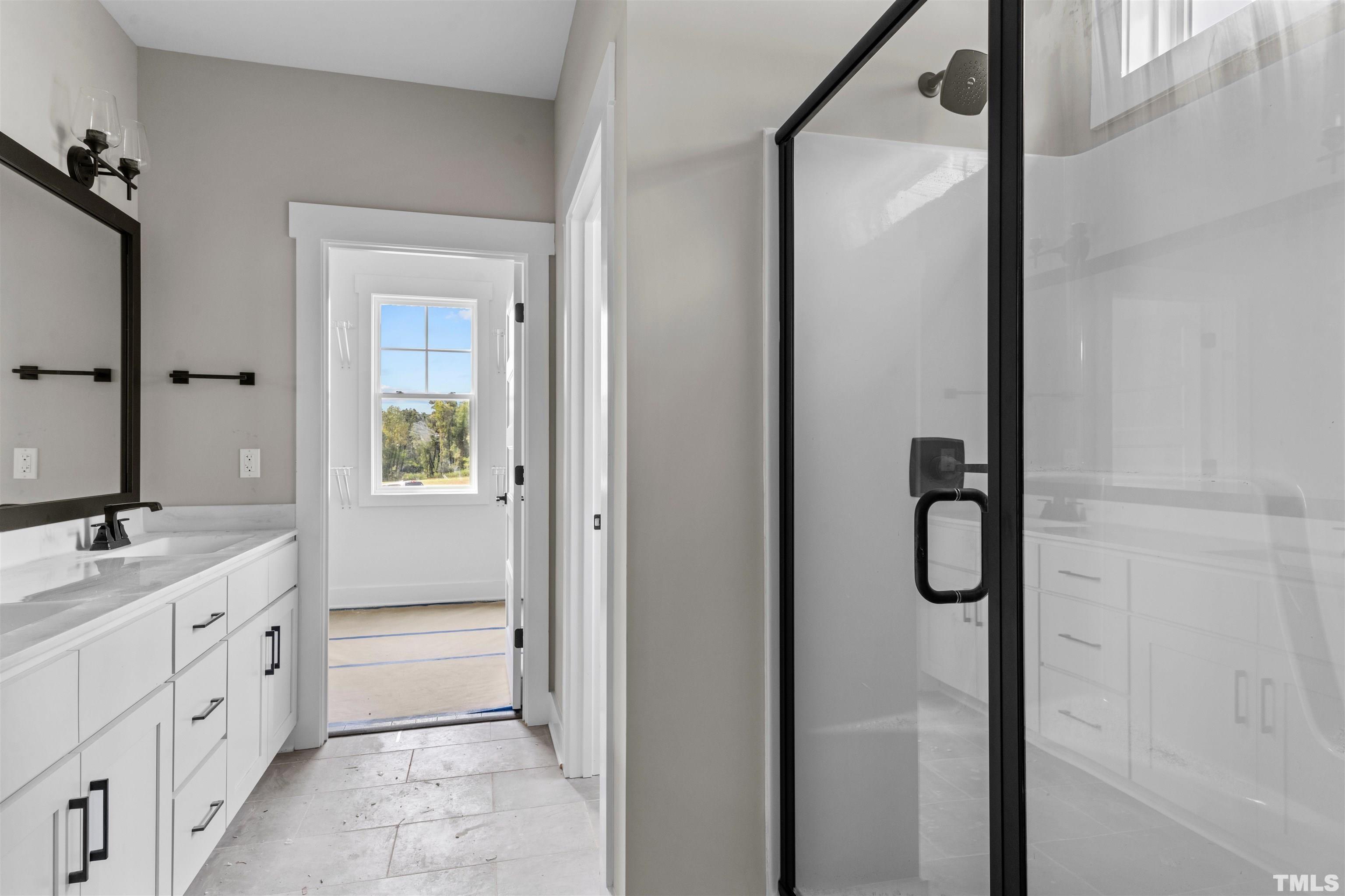 97 Buckstone Place Willow Spring, NC 27592 - Photo 19 of 21 a bathroom with a double vanity sink a mirror and a bathtub