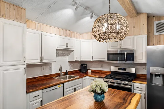 a kitchen with stainless steel appliances a stove a refrigerator and a sink