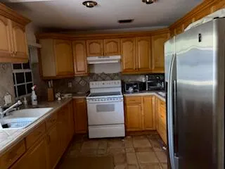 a kitchen with a refrigerator sink and cabinets