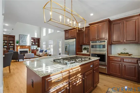 a kitchen with stainless steel appliances granite countertop a stove refrigerator and cabinets