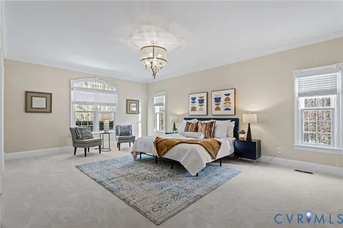 a bedroom with a large bed and a chandelier