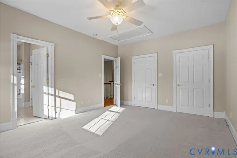 an empty room with windows and fan