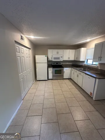 a kitchen with stainless steel appliances granite countertop a stove a sink and a granite counter tops