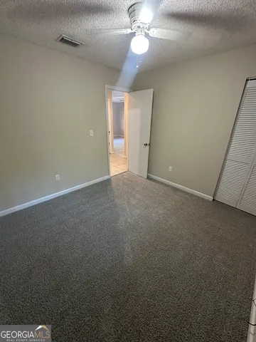 a view of an empty room with a chandelier fan