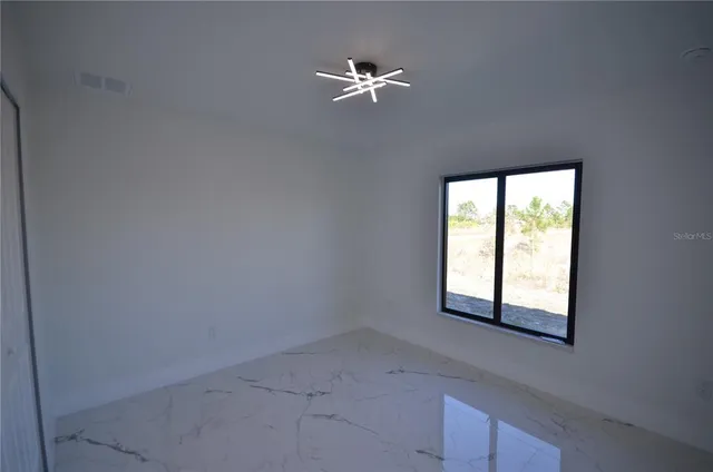 an empty room with a window and a ceiling fan