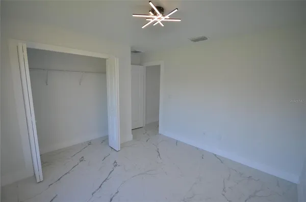 an empty room with a ceiling fan and a window