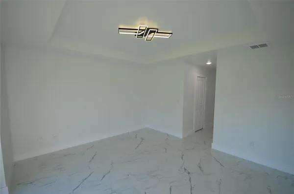 an empty room with windows and a ceiling fan