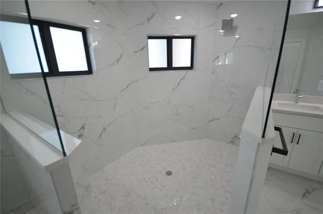 a spacious bathroom with a double vanity sink a mirror and a bathtub