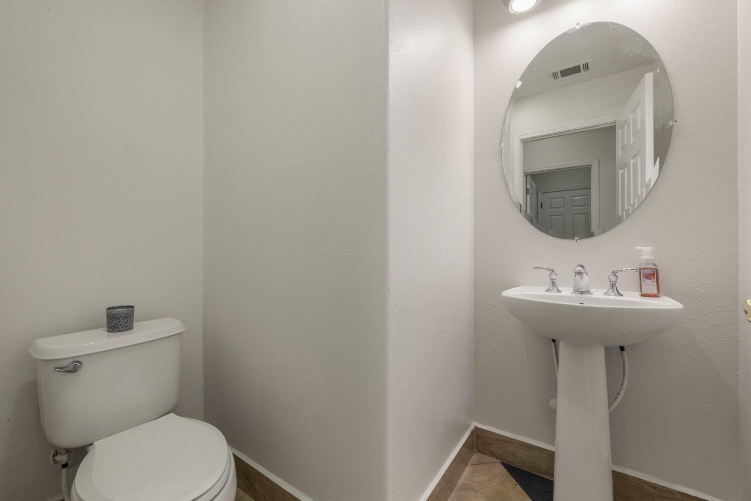 3105 Ripple Court Modesto, CA 95355 - Photo 21 of 46 a bathroom with a toilet a sink and mirror