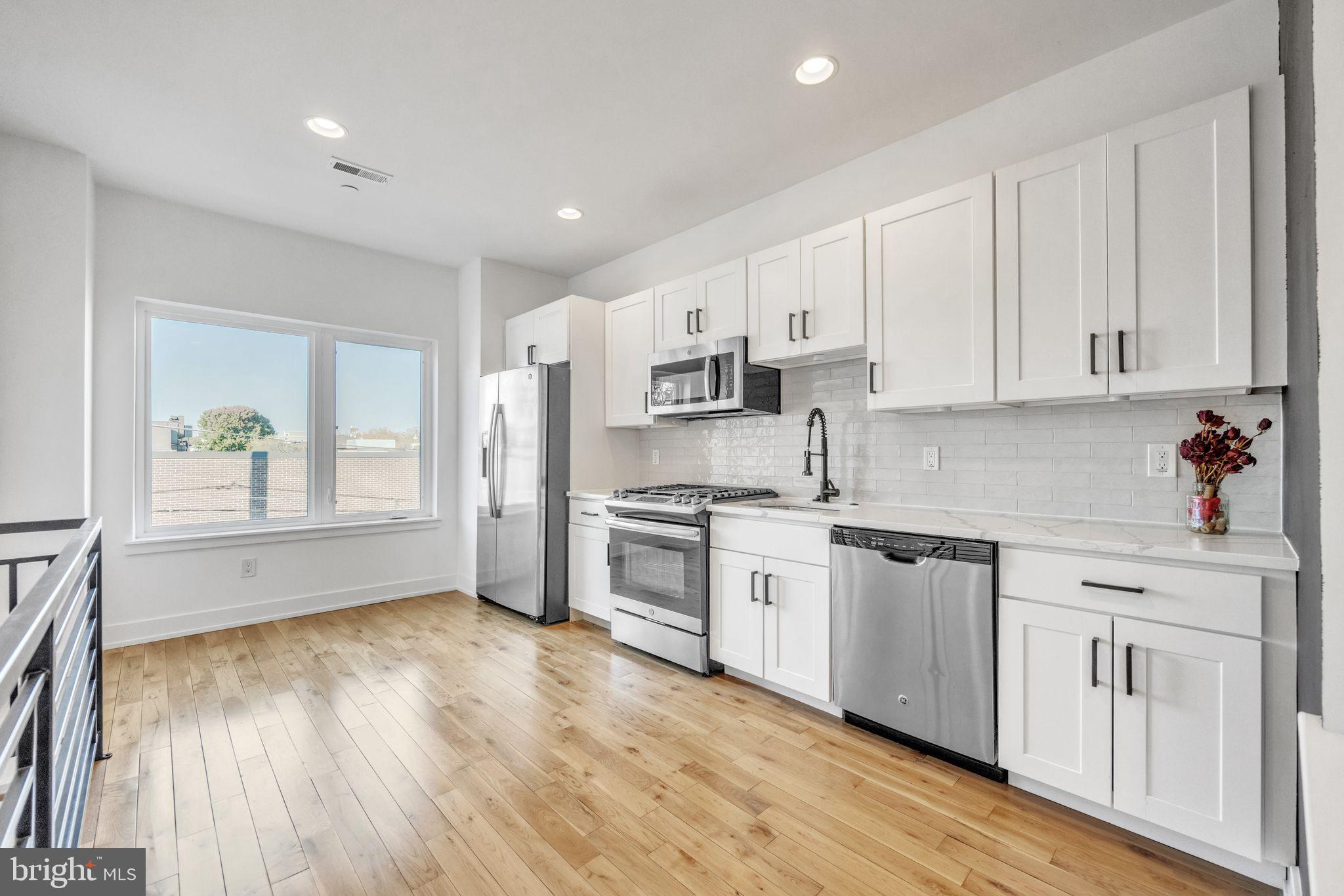 614 Master Street, Unit 2 Philadelphia, PA 19122 - Photo 2 of 29 a kitchen with granite countertop white cabinets and white appliances