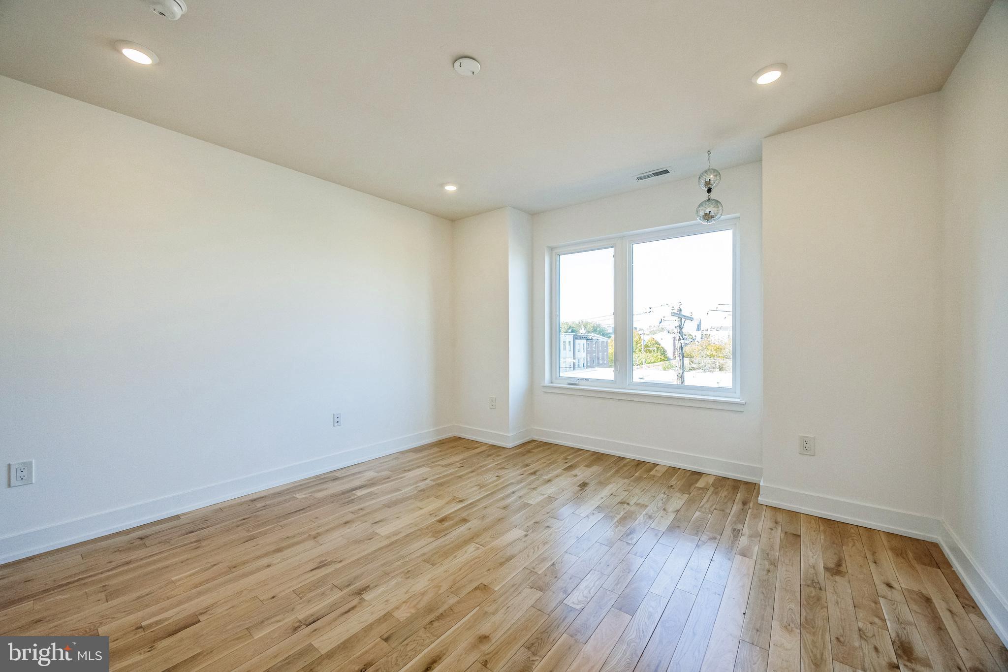 614 Master Street, Unit 2 Philadelphia, PA 19122 - Photo 25 of 29 an empty room with wooden floor and windows