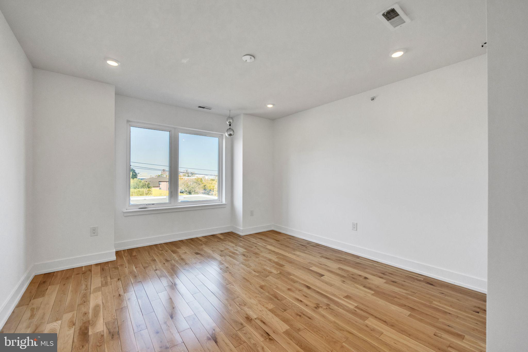 614 Master Street, Unit 2 Philadelphia, PA 19122 - Photo 26 of 29 a view of an empty room with wooden floor and a window