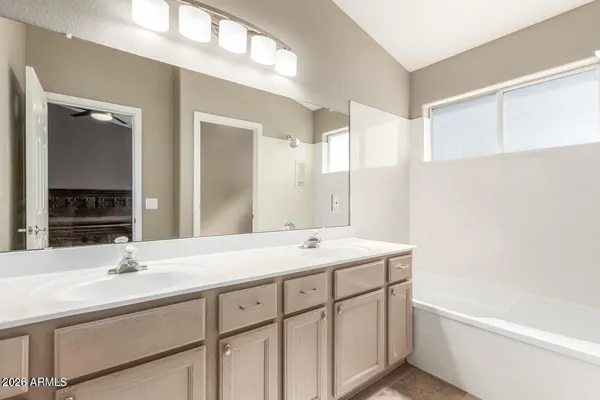 a bathroom with a sink double vanity granite tub and a mirror
