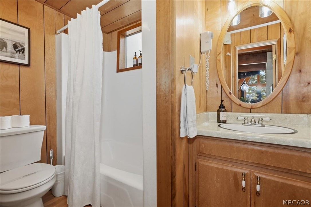 1146 Ridge Road Fawnskin, CA 92333 - Photo 18 of 34 a bathroom with a granite countertop sink a toilet and a mirror
