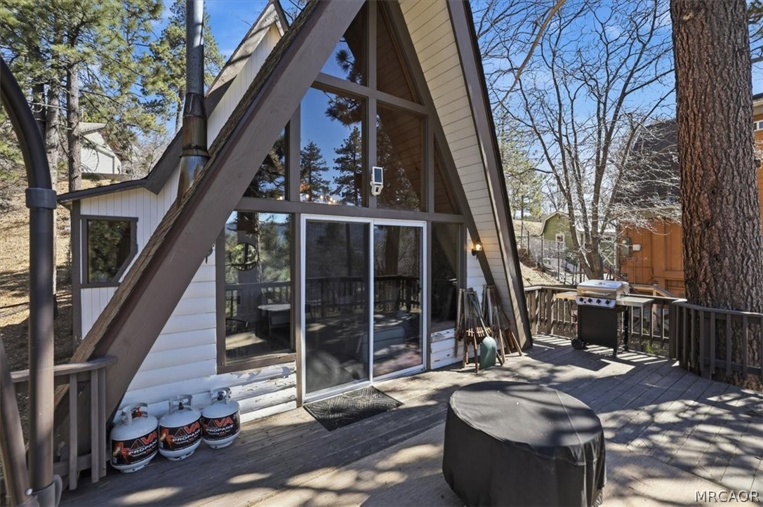 1146 Ridge Road Fawnskin, CA 92333 - Photo 27 of 34 a view of a patio with table and chairs and floor to ceiling window with wooden fence