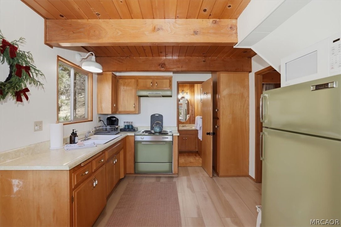 1146 Ridge Road Fawnskin, CA 92333 - Photo 9 of 34 a kitchen with a sink a refrigerator and cabinets