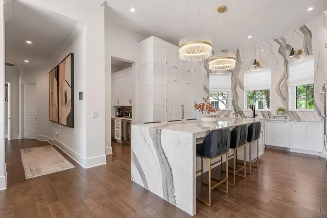 a view of a white house with a yard and potted plants