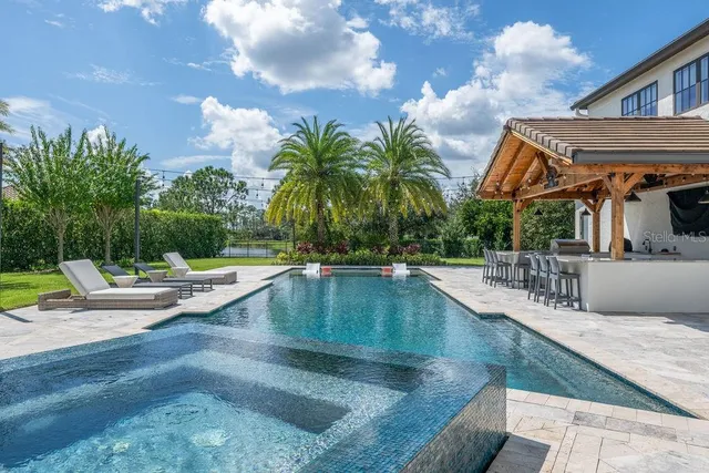 a view of a house with swimming pool and sitting area