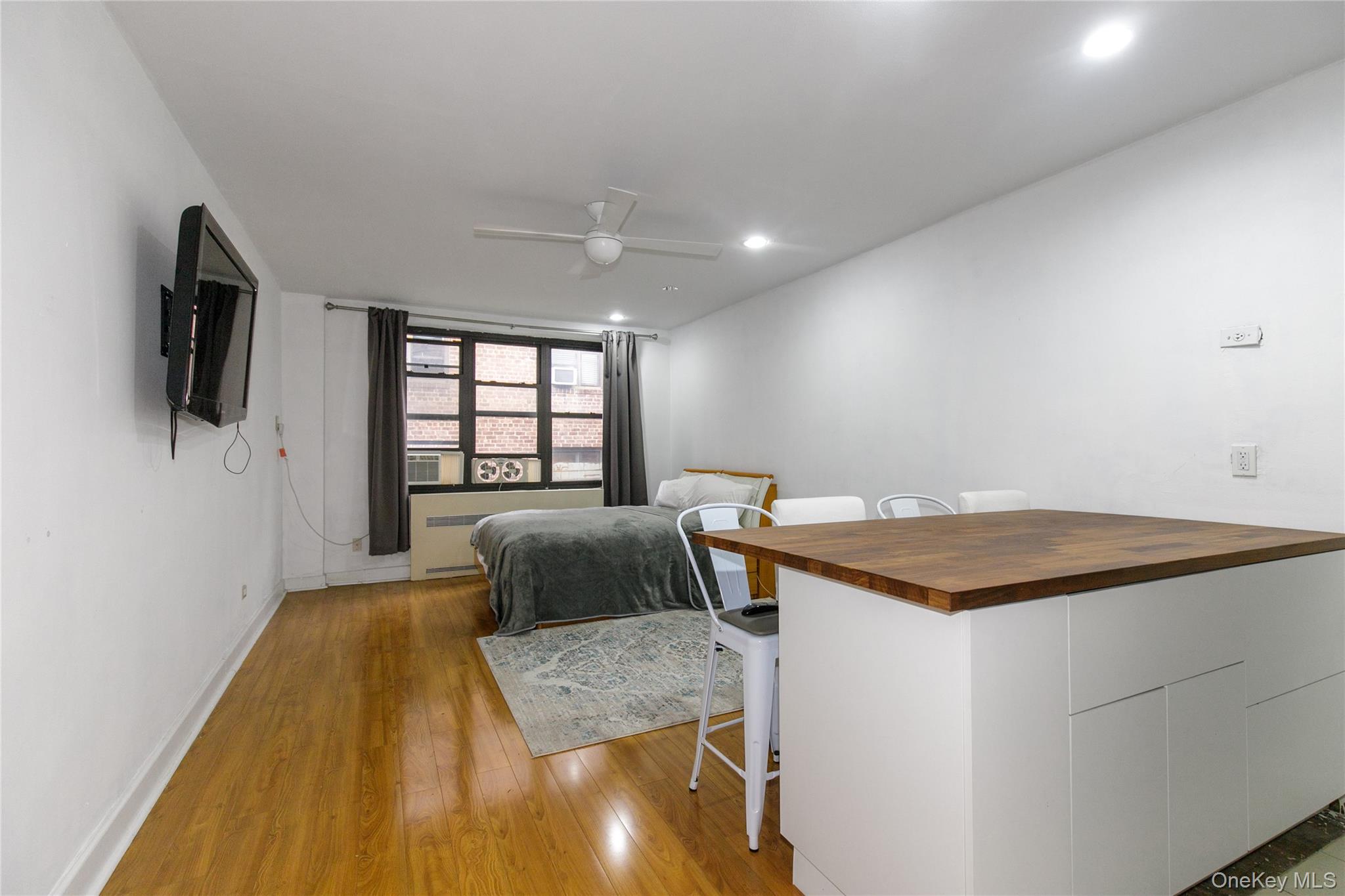 15 Canterbury Road, Unit C10 Great Neck, NY 11021 - Photo 2 of 22 a bedroom with a bed and a flat screen tv