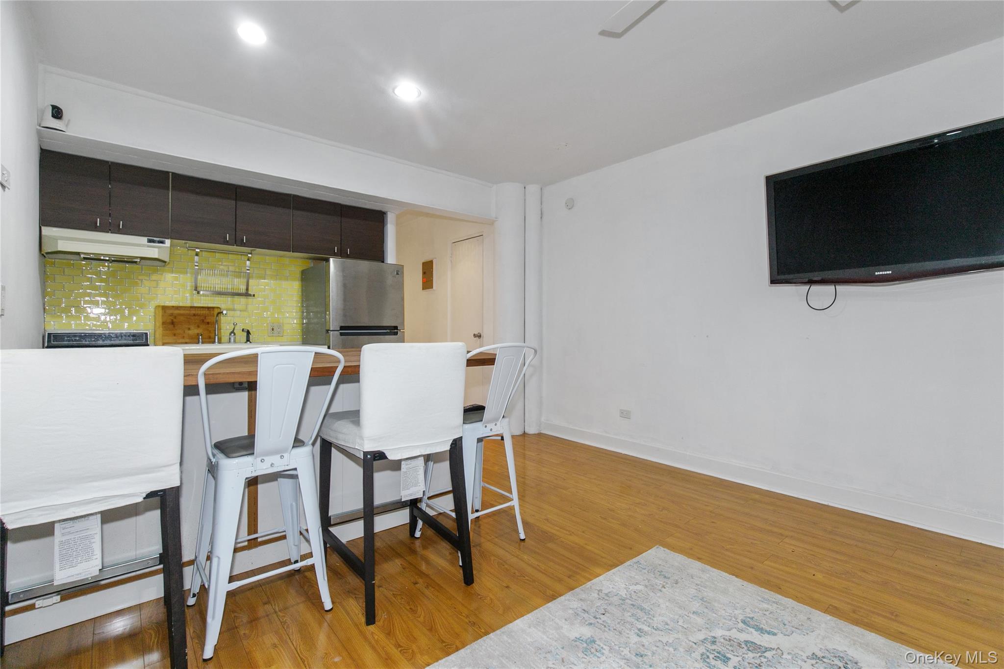 15 Canterbury Road, Unit C10 Great Neck, NY 11021 - Photo 7 of 22 a view of a dining room with furniture and a flat screen tv