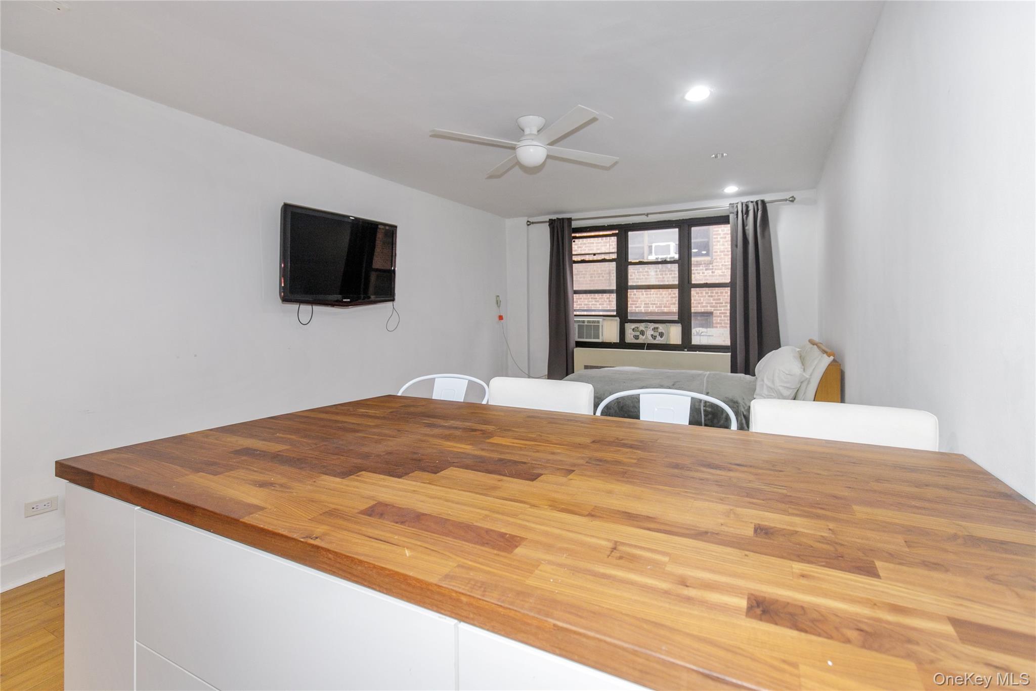 15 Canterbury Road, Unit C10 Great Neck, NY 11021 - Photo 10 of 22 a bedroom with a bed and a flat screen tv