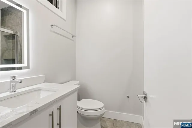 a bathroom with a granite countertop sink toilet and a mirror