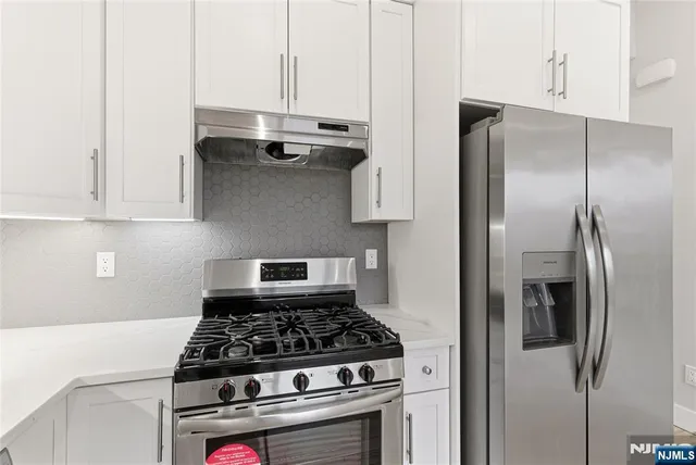 a stove top oven sitting inside of a kitchen