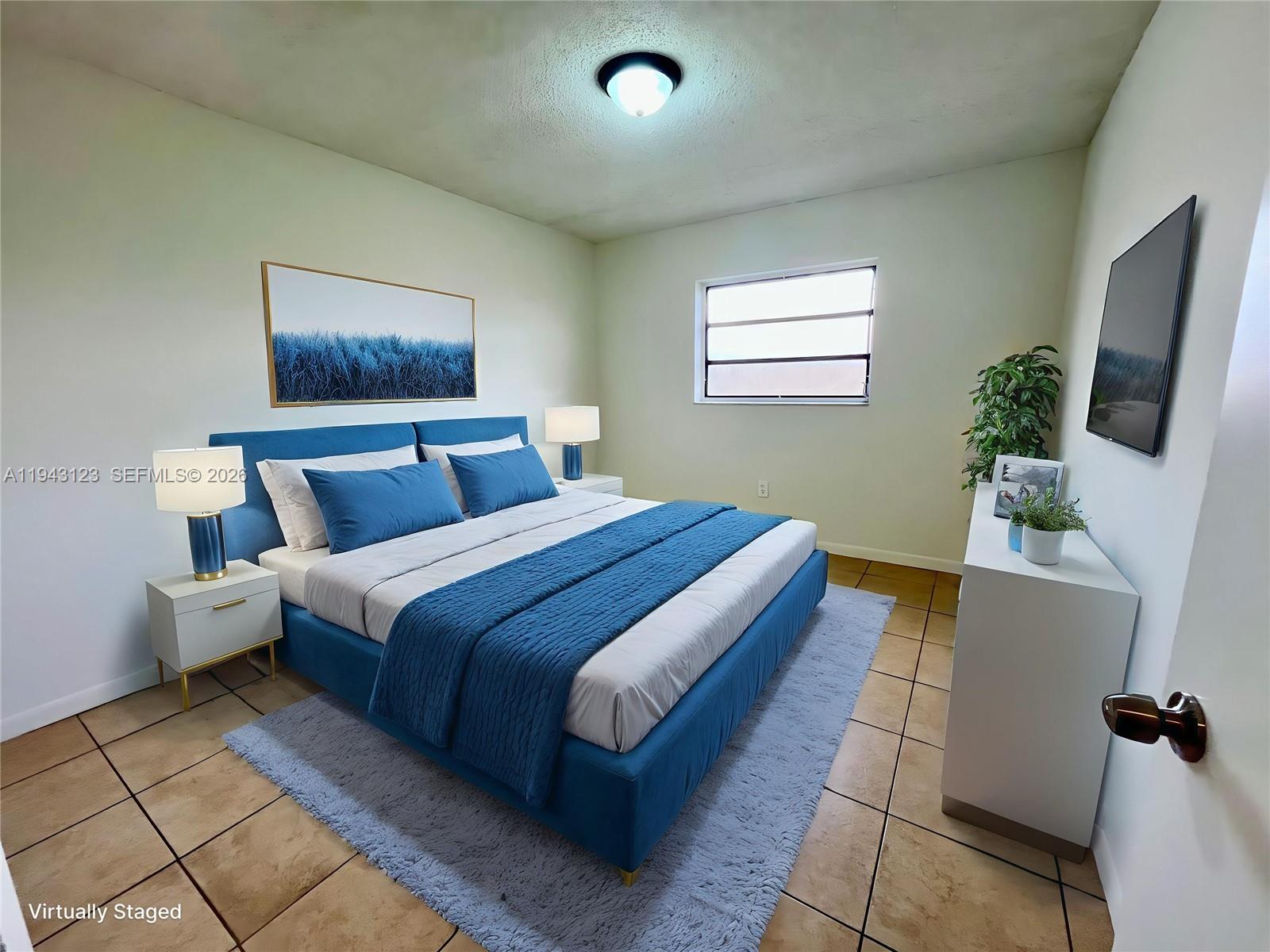 1127 West 37th Street Hialeah, FL 33012 - Photo 5 of 16 a bedroom with a bed and a flat screen tv