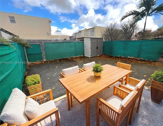 a view of a patio with table and chairs with wooden fence and plants