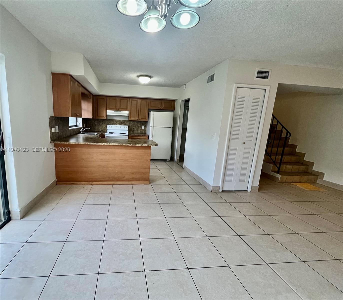 1127 West 37th Street Hialeah, FL 33012 - Photo 10 of 16 a kitchen with stainless steel appliances granite countertop a stove a sink and a refrigerator