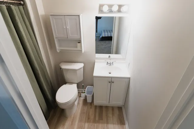 a bathroom with a toilet a sink and a mirror